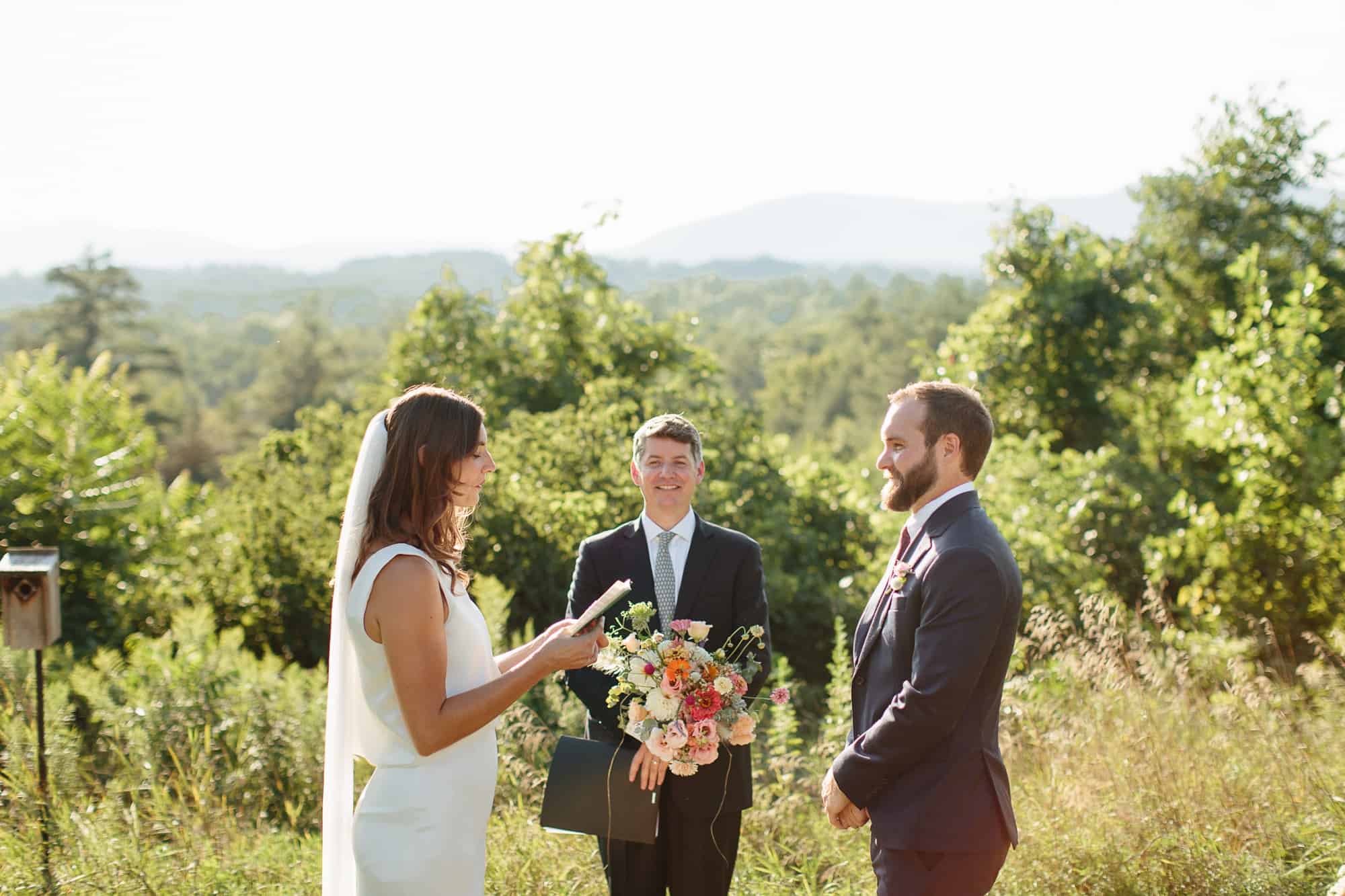 Bride and groom exchanging vows by Adirondack wedding photographers The Light + Color