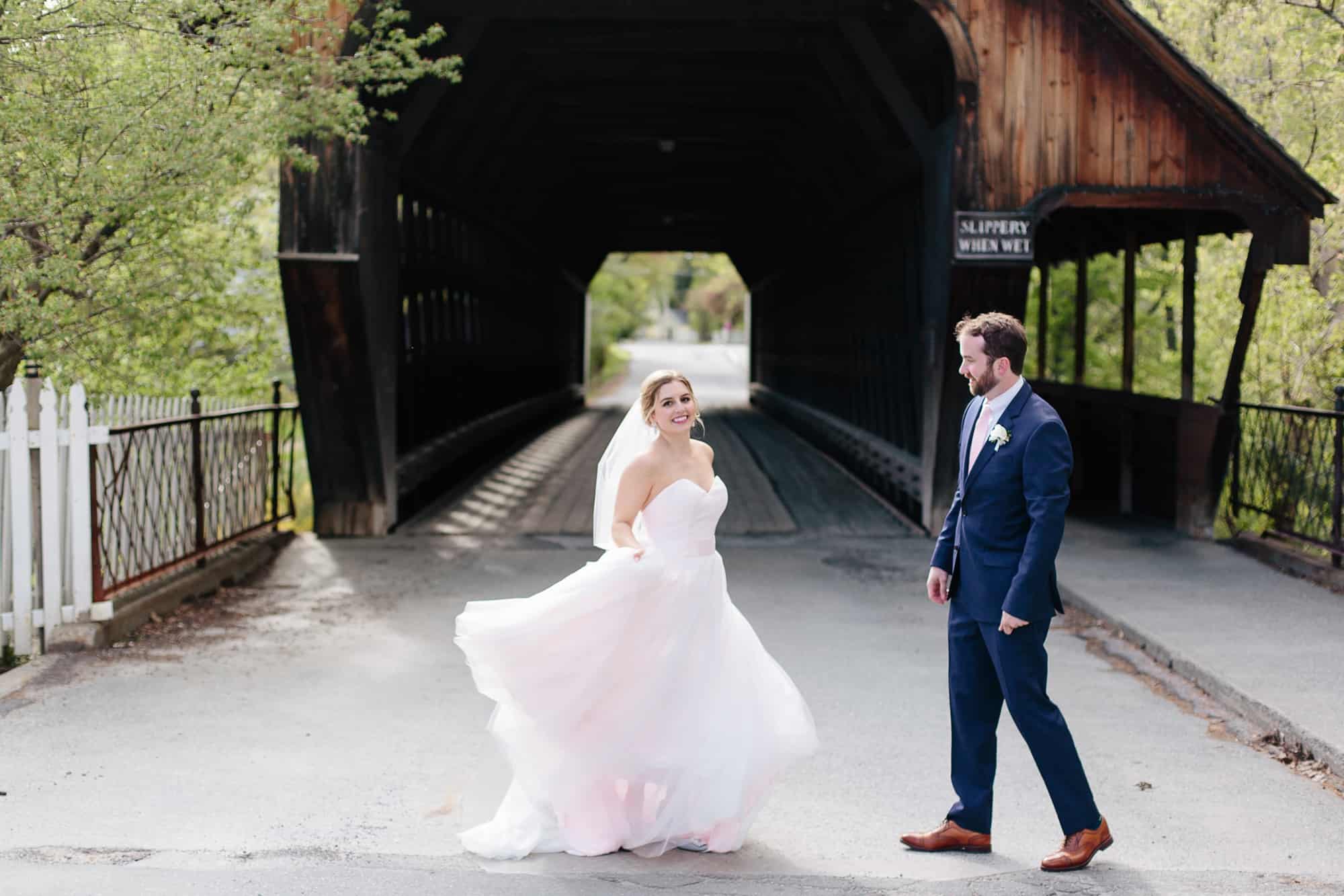 Couple dancing in front of covered bridge in Woodstock, VT