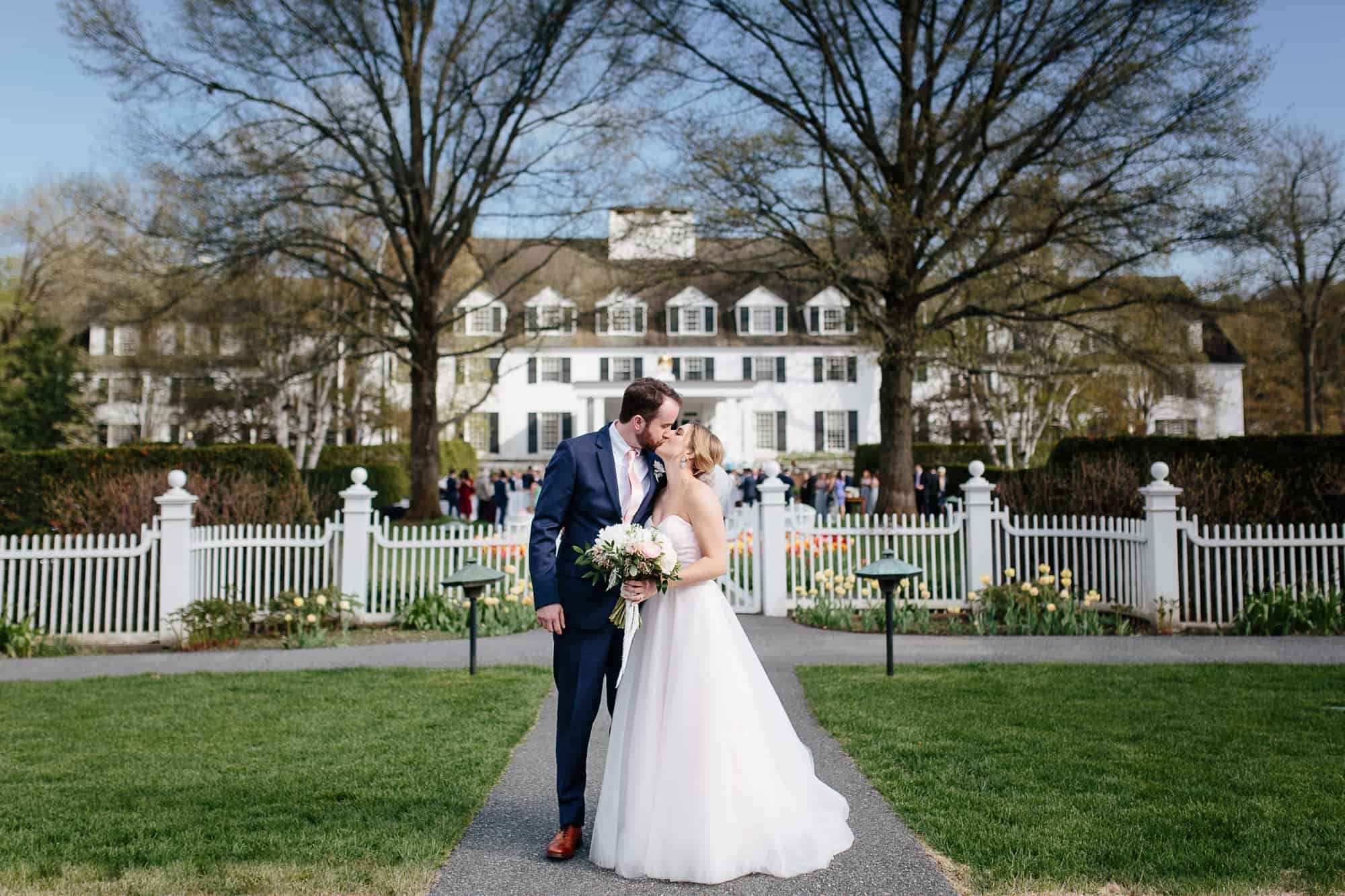 Couple kissing in front of their woodstock inn wedding