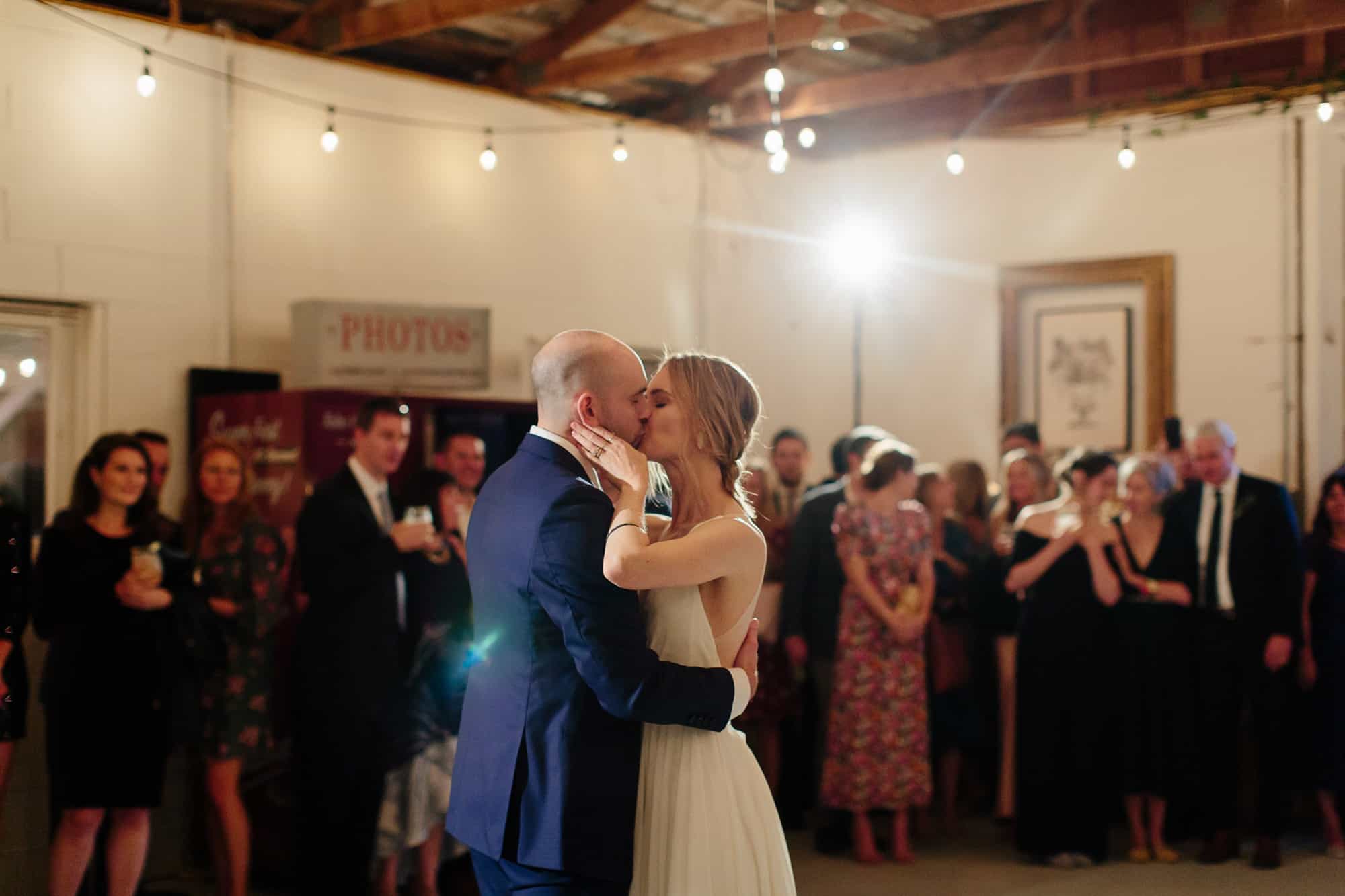 bride and groom kiss after first dance at M&D farm wedding capture by Catskills wedding photographers The Light and Color