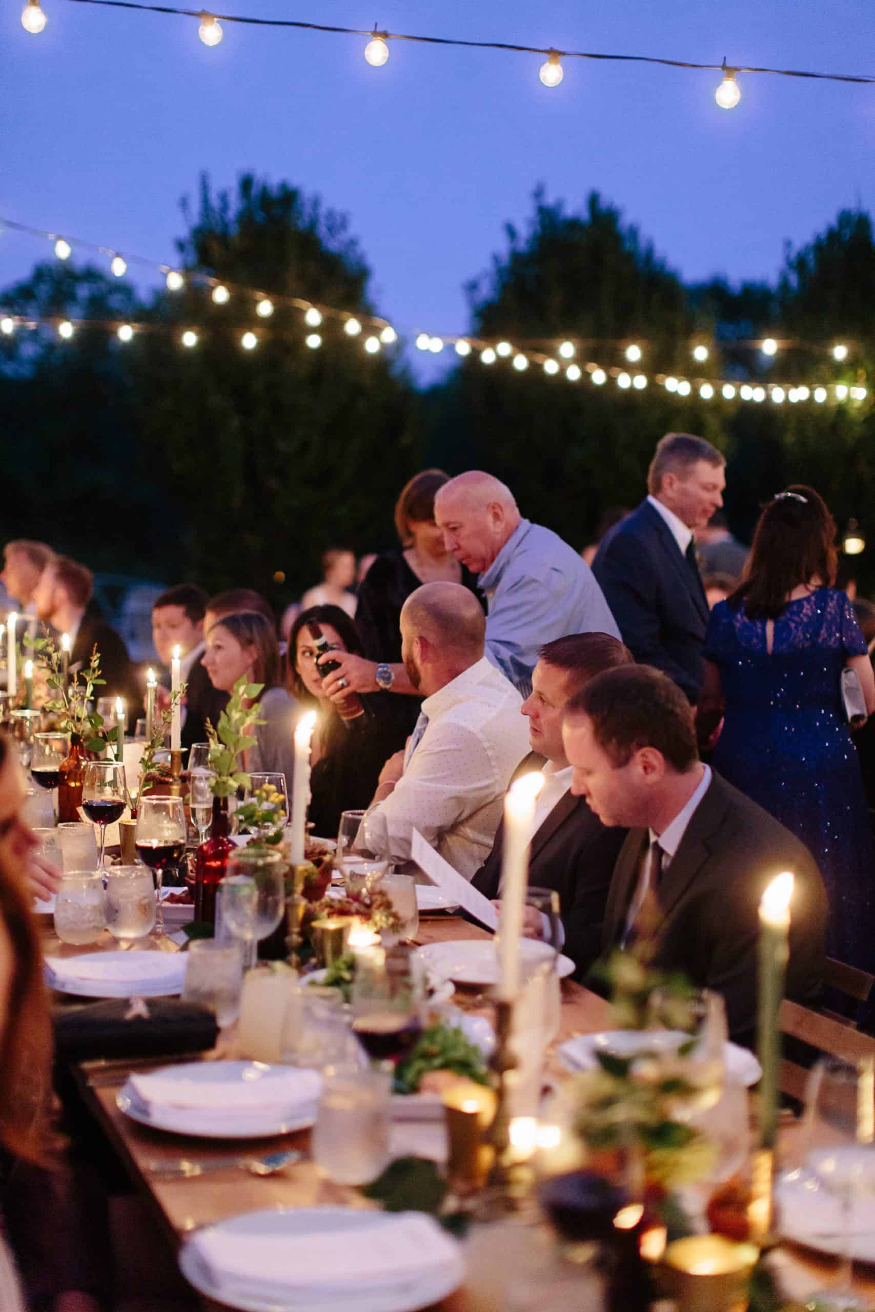Guests enjoying dinner at M&D farm wedding capture by Upstate new york wedding photographers The Light and Color