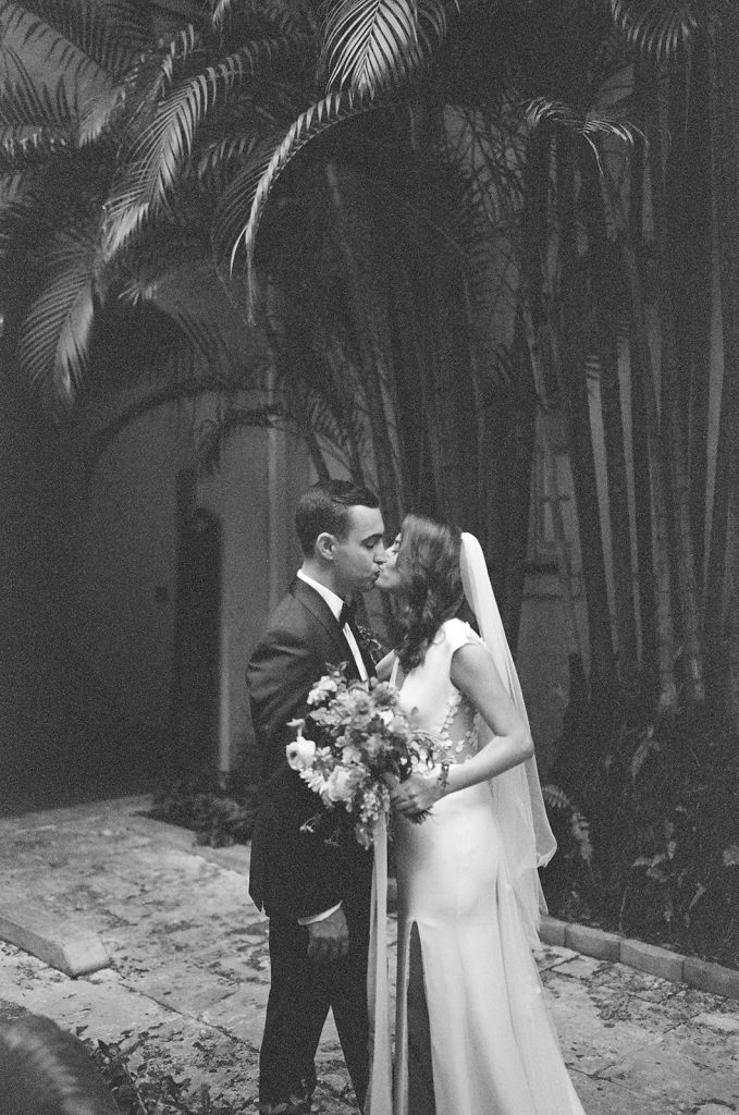 Bride and Groom kissing in courtyard of Villa Woodbine wedding