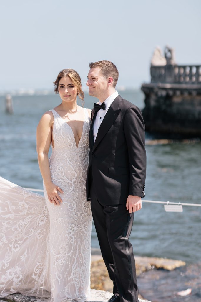 Bride and groom stand by ocean front at Vizcaya wedding